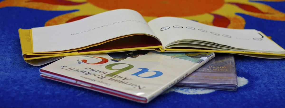 Children's books spread on colorful carpet