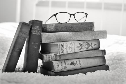 stack of books with glasses