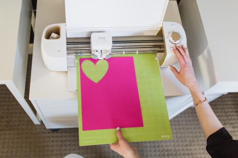 A heart being cut out on a Cricut machine