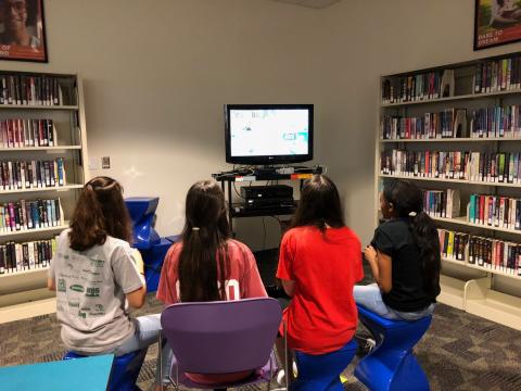 Teens playing video games in the library.