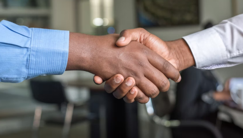 close up of two people shaking hands in a professional setting