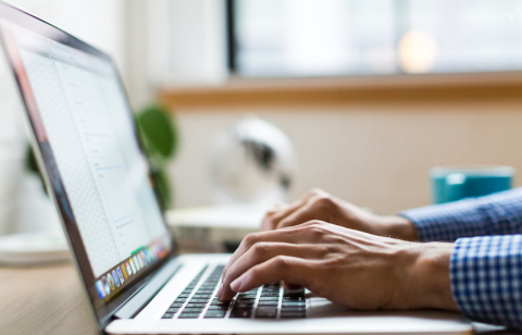 close up of hands typing on a laptop