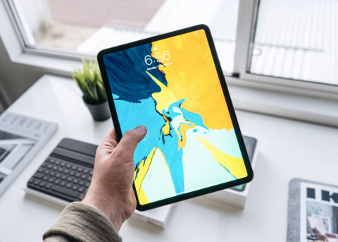 close up of a person's hand holding a tablet