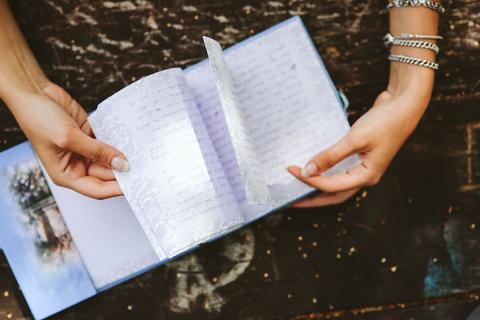 Woman's hands holding a handwritten journal