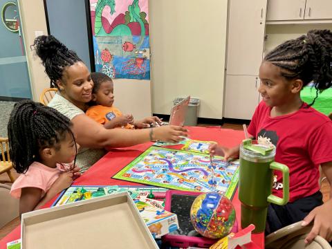 Johnson Family playing a board game at George Memorial Library Game Room