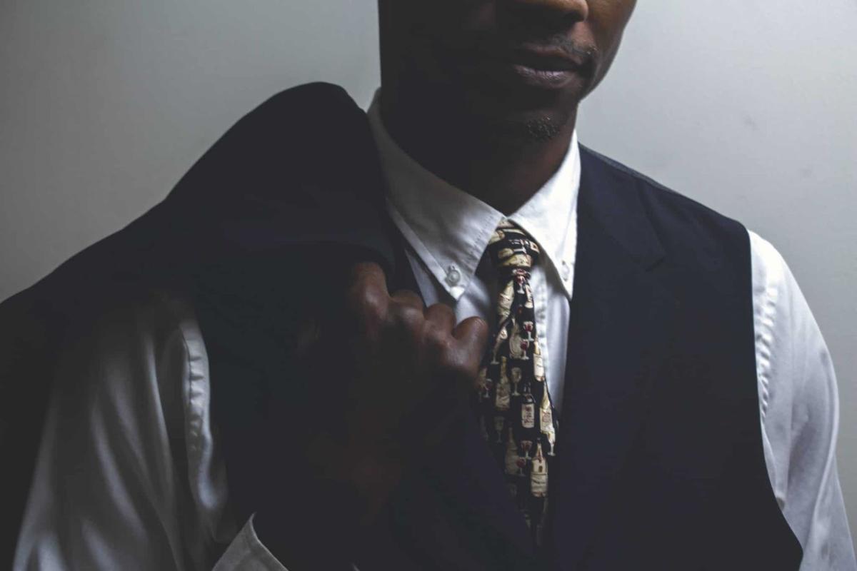 Man in a tie and waistcoat, holding a jacket