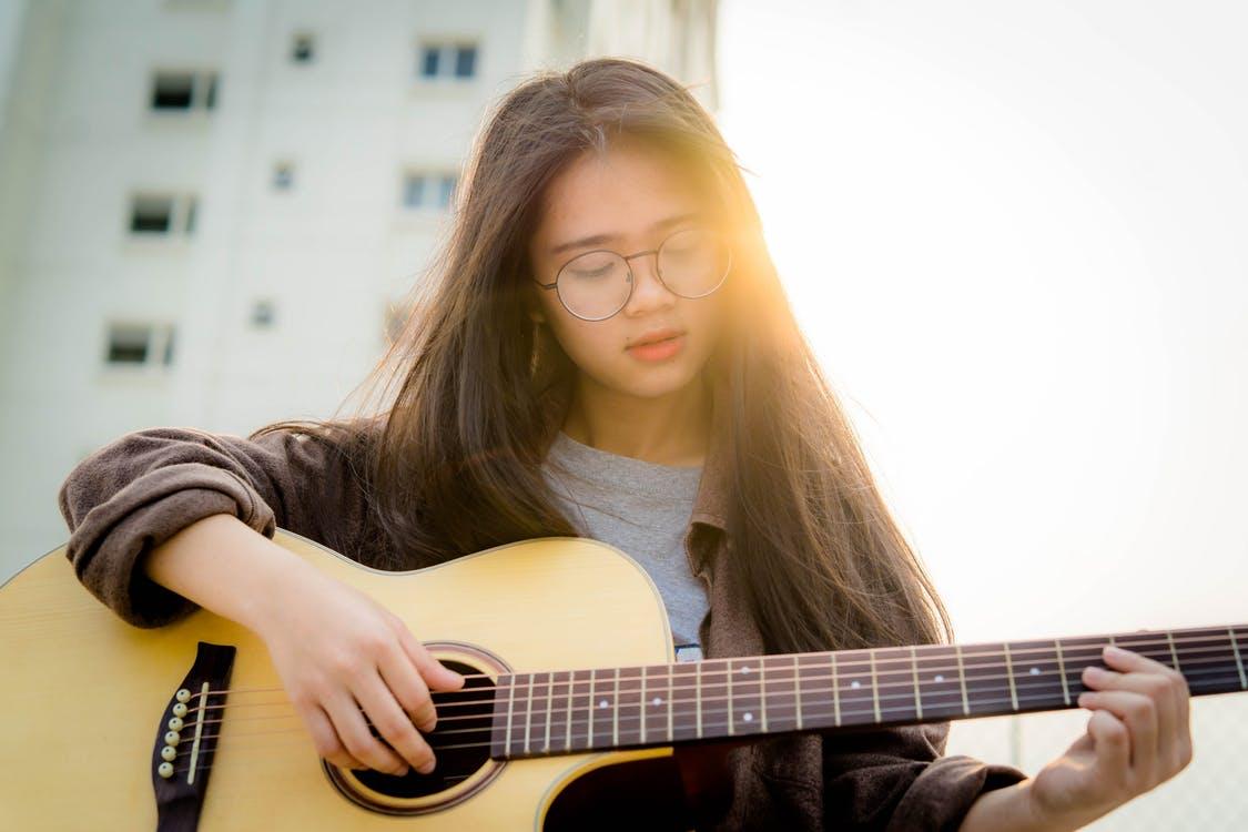 Teenage girl playing guitar