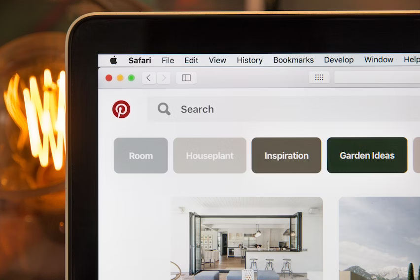 close up of the corner of a laptop screen displaying the Pinterest logo 