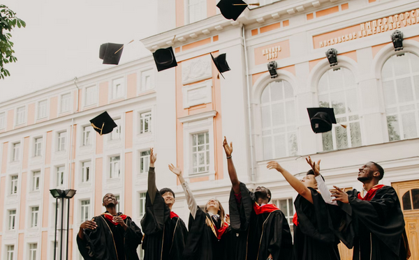 photo of college graduates tossing graduation caps