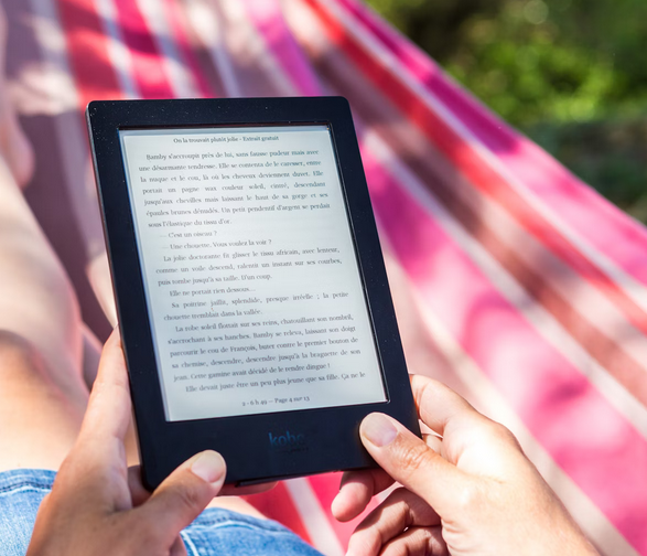 photo of someone holding a kobo ereader while lying in a pink striped hammock