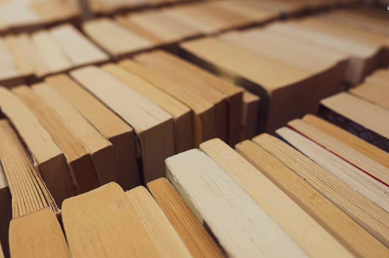 close up of the tops of books with the pages yellowed from age