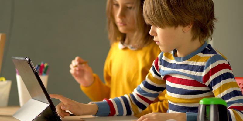 Two children studying on a tablet computer