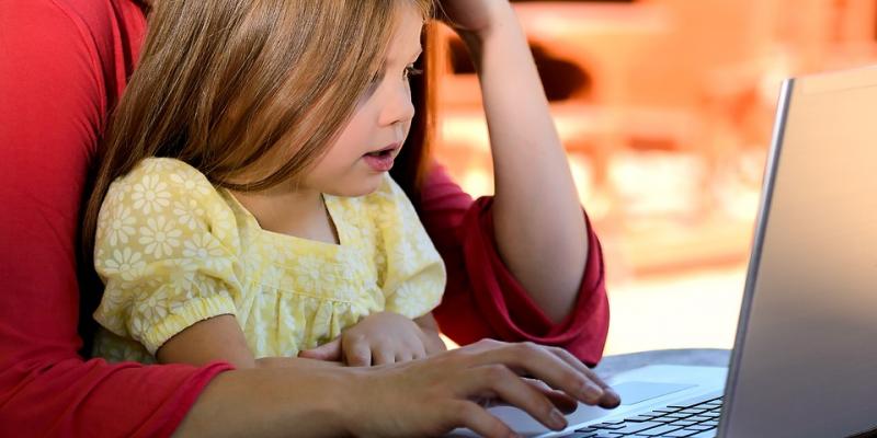 Young girl and adult with laptop