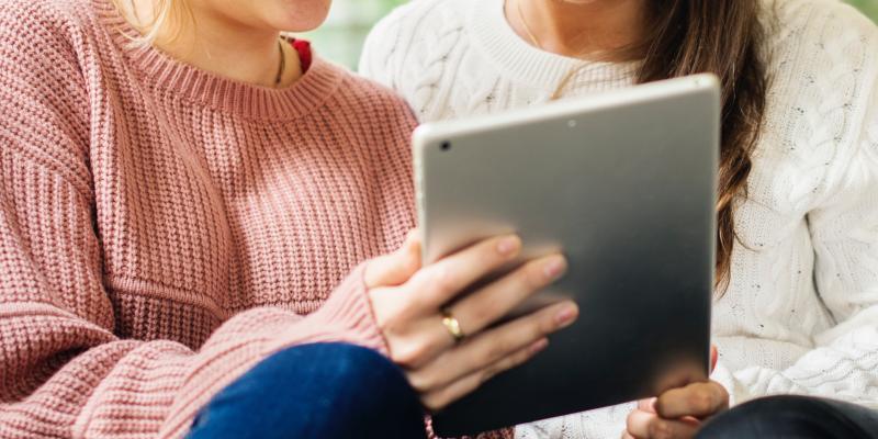 two girls holding tablet