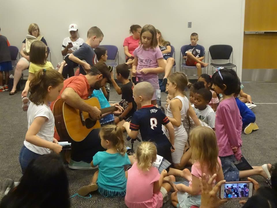 Man playing guitar for children